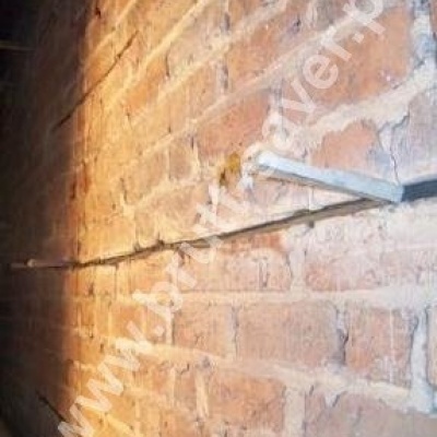 Naprawa muru z cegły. Widoczne kliny stabilizujące profile śrubowe Brutt'a w czasie wstępnego wiązania zaprawy Saver Powder.