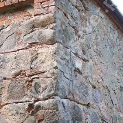 Naprawa popękanego muru z kamienia (naroża) z zastosowaniem Saver Profili. Montaż profili śrubowych w spoinach pomiędzy kamieniami.